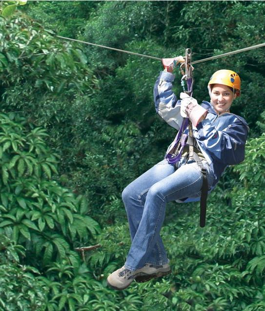 Lady sliding down canopy tree tops in Guanacaste Costa Rica 