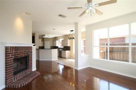 Den with gorgeous Wood Laminate 5 inch plank flooring, new paint & Wood burning Gas Starter Brick Fireplace with Mantle